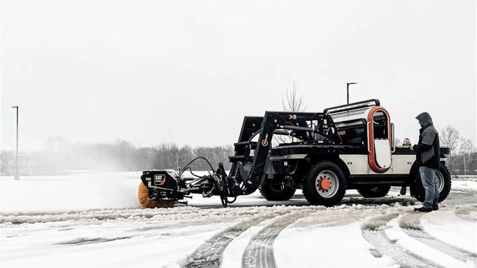 DANNAR Infrastructure Maintenance DANNAR Electric work vehicle removing snow as worker controls the machine with a remote control